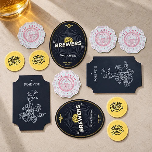 Printed stickers in various sizes and shapes, including yellow thank-you circles, oval brewery labels, scalloped ice cream labels and decorative rectangular wine labels.